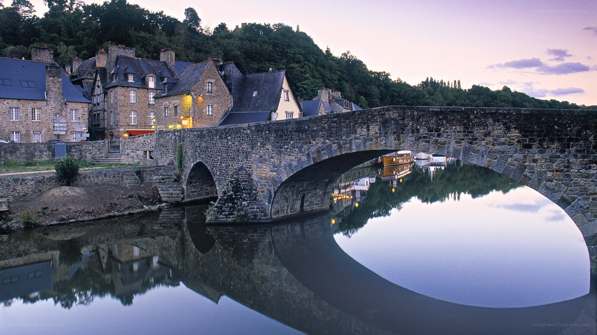 Stone bridge over river at dusk