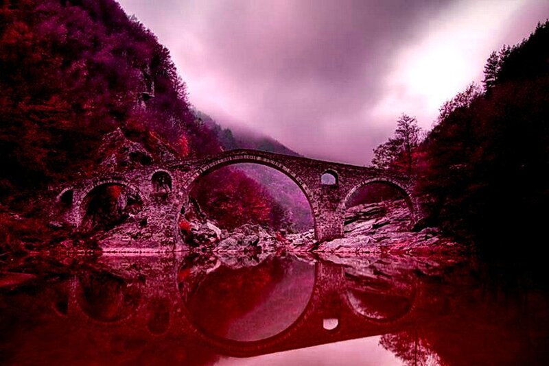 Stone bridge over river at dusk