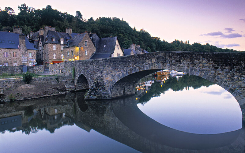 Stone bridge over river at dusk