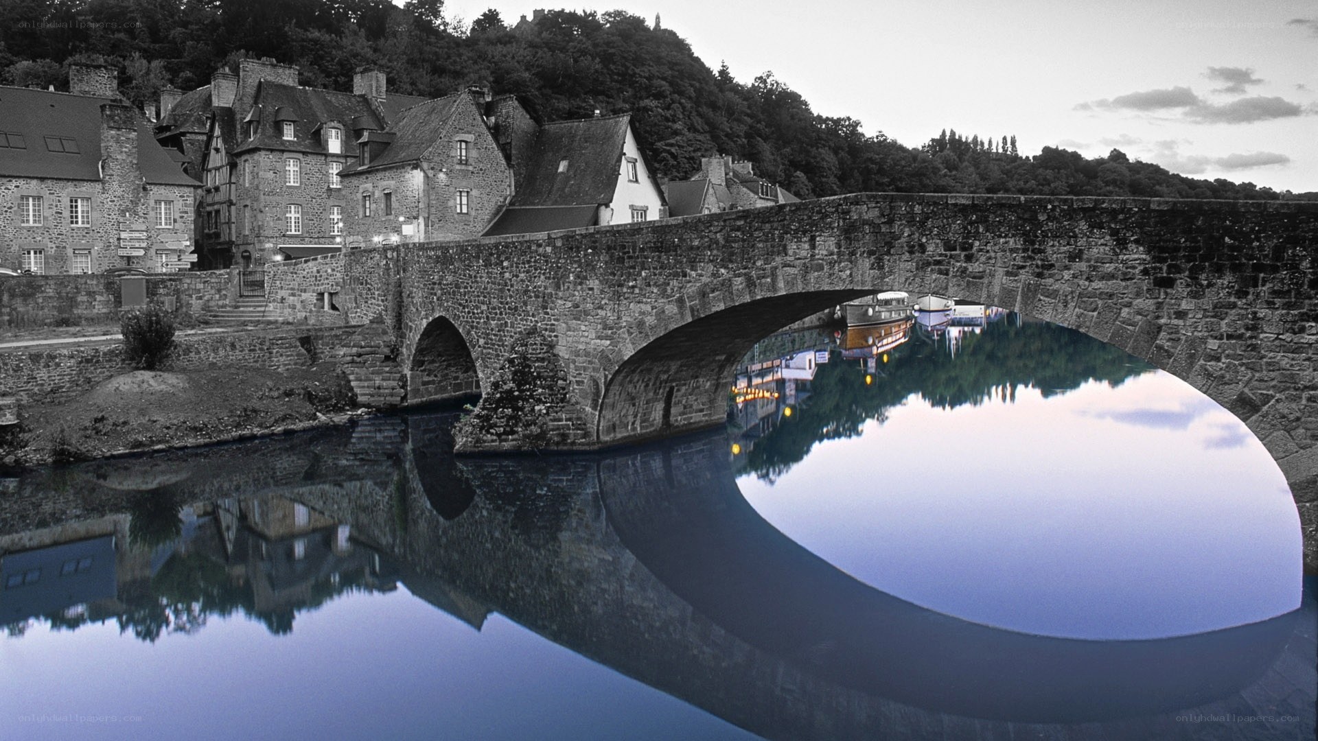 Stone bridge over river at dusk