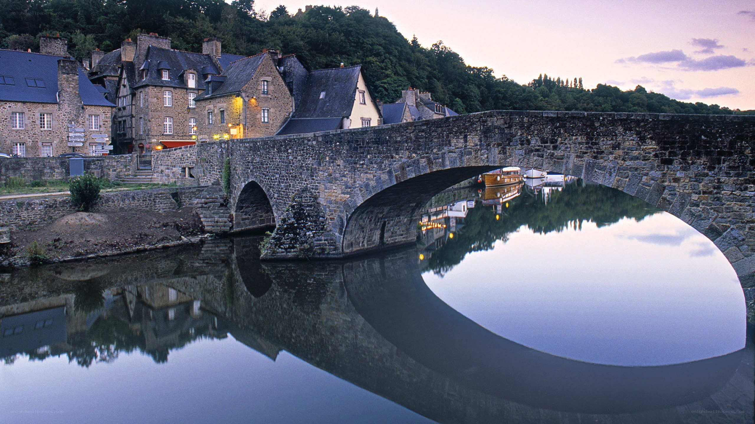 Stone bridge over river at dusk