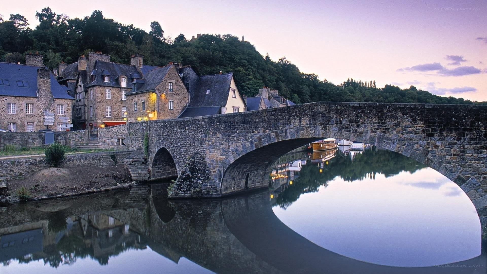 Stone bridge over river at dusk