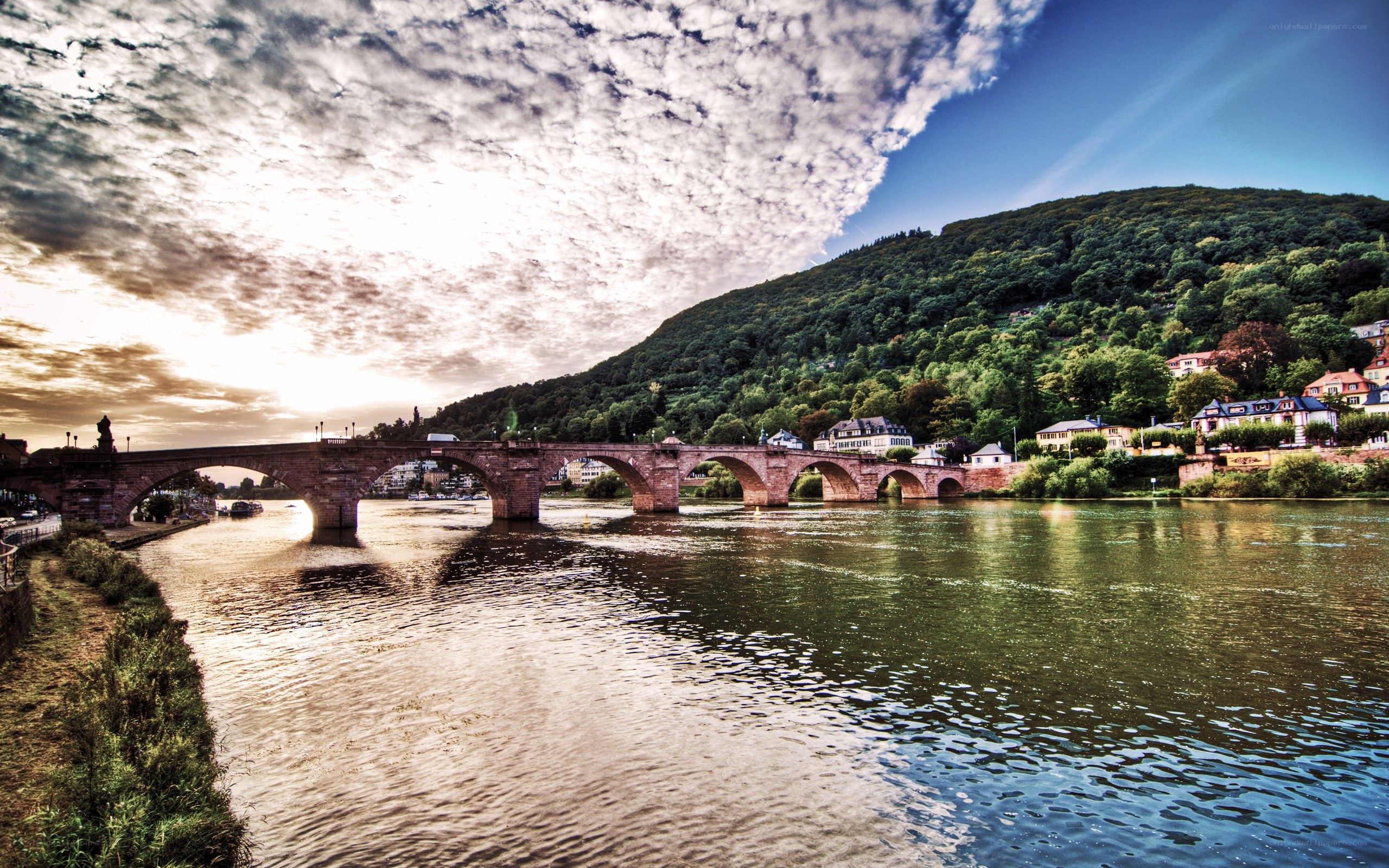 Stone bridge over river at sunset