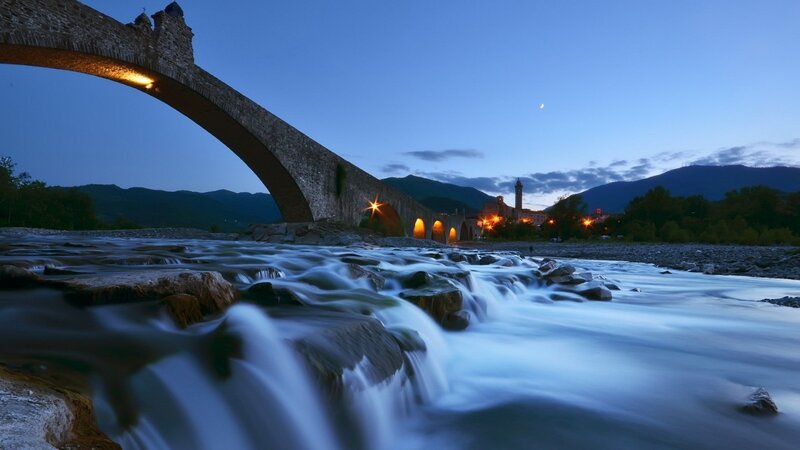 Stone Bridge over River — Blue, Serene, Night, Photograph, Mountains