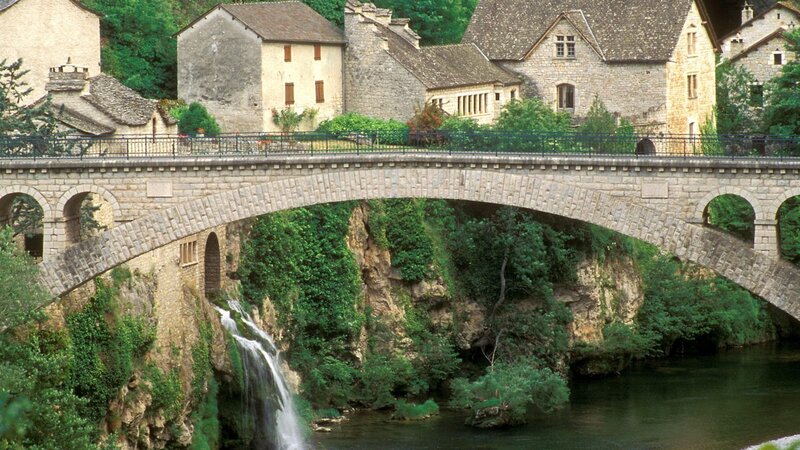 Stone Bridge over River — Green, Serene, Afternoon, Photograph, Buildings, Trees, Brown