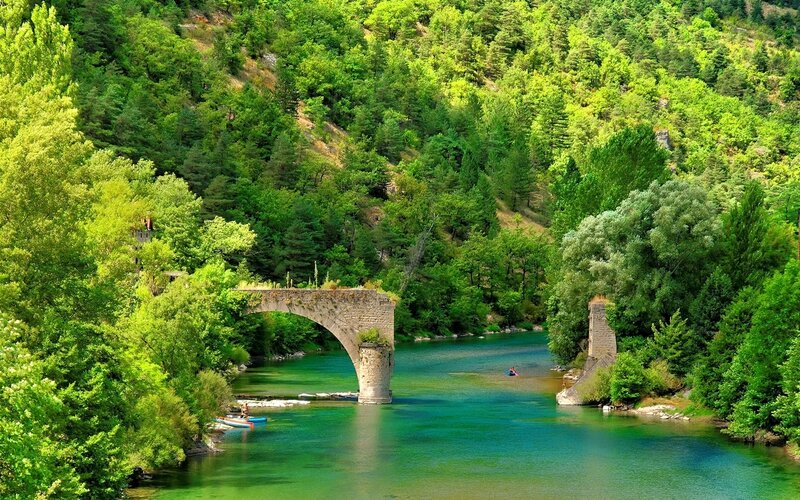 Stone Bridge over River — Green, Serene, Afternoon, Photograph, Trees, Canoes