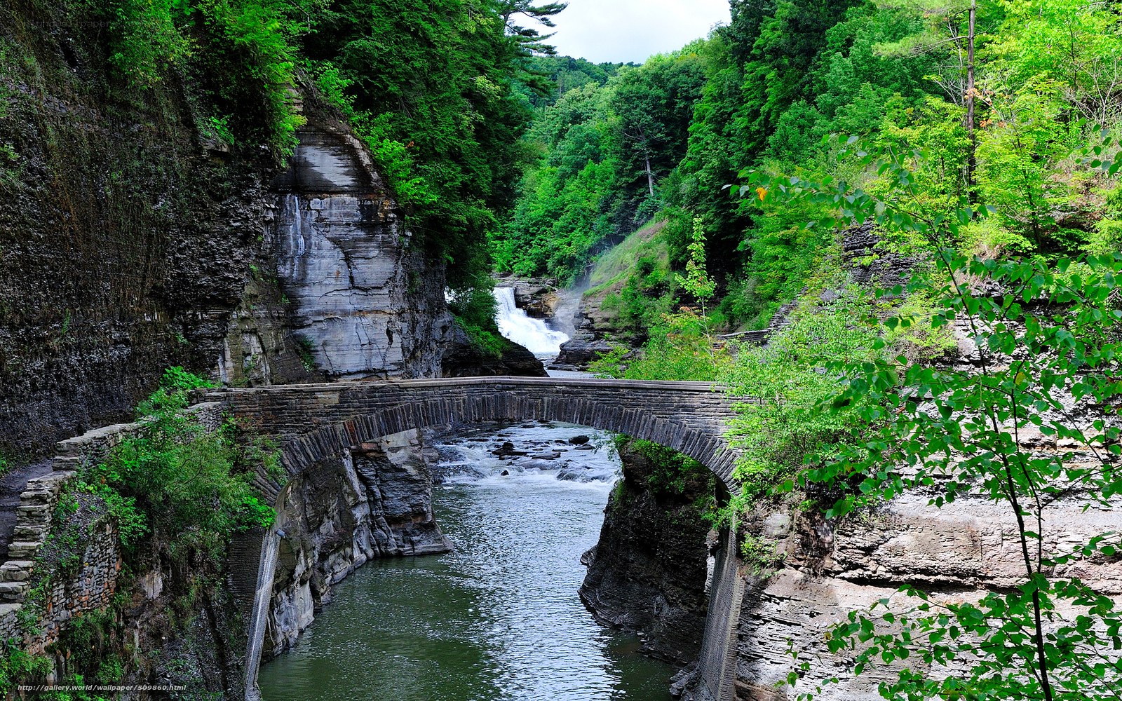 Stone bridge over river in canyon