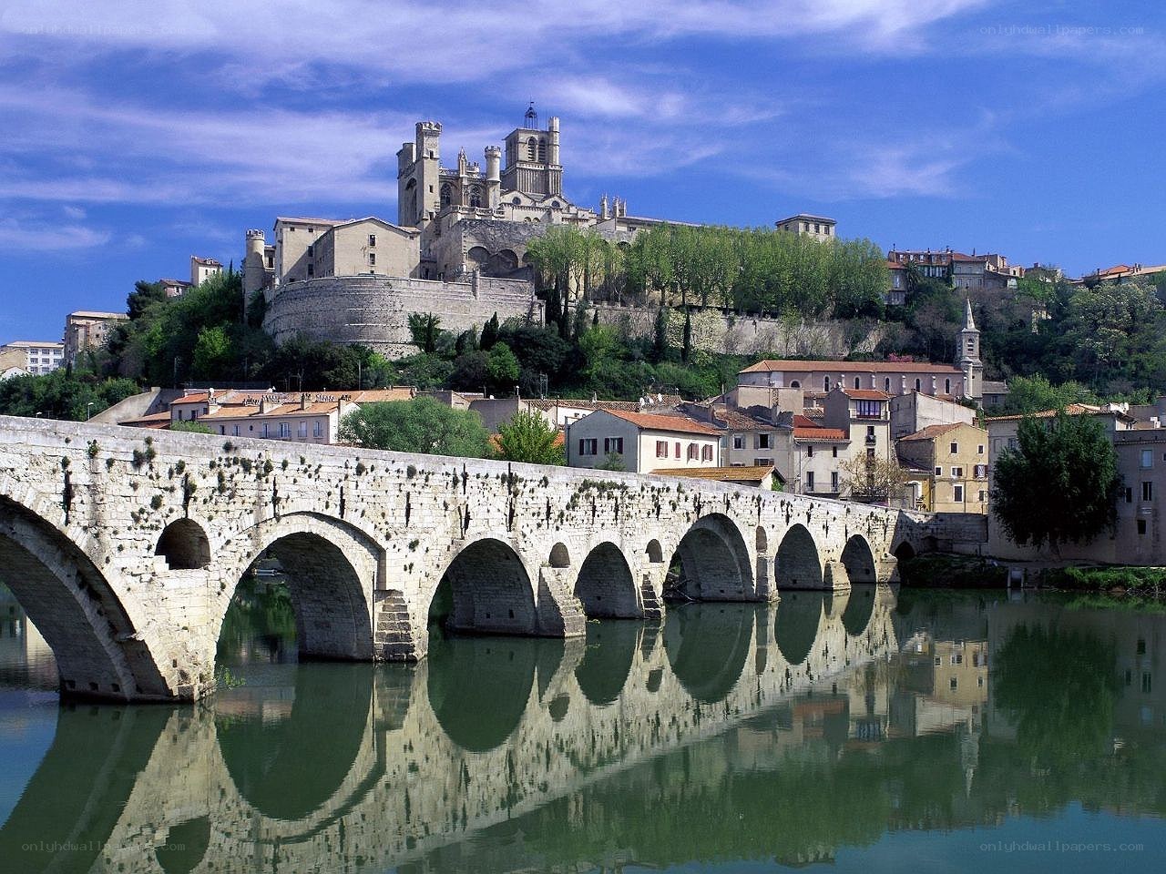 Stone bridge over river with cathedral
