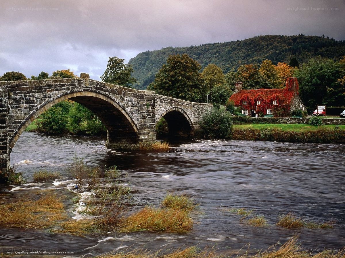 Stone bridge over river with cottage