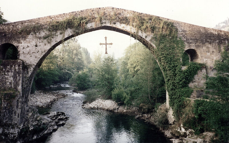 Stone bridge over river with cross