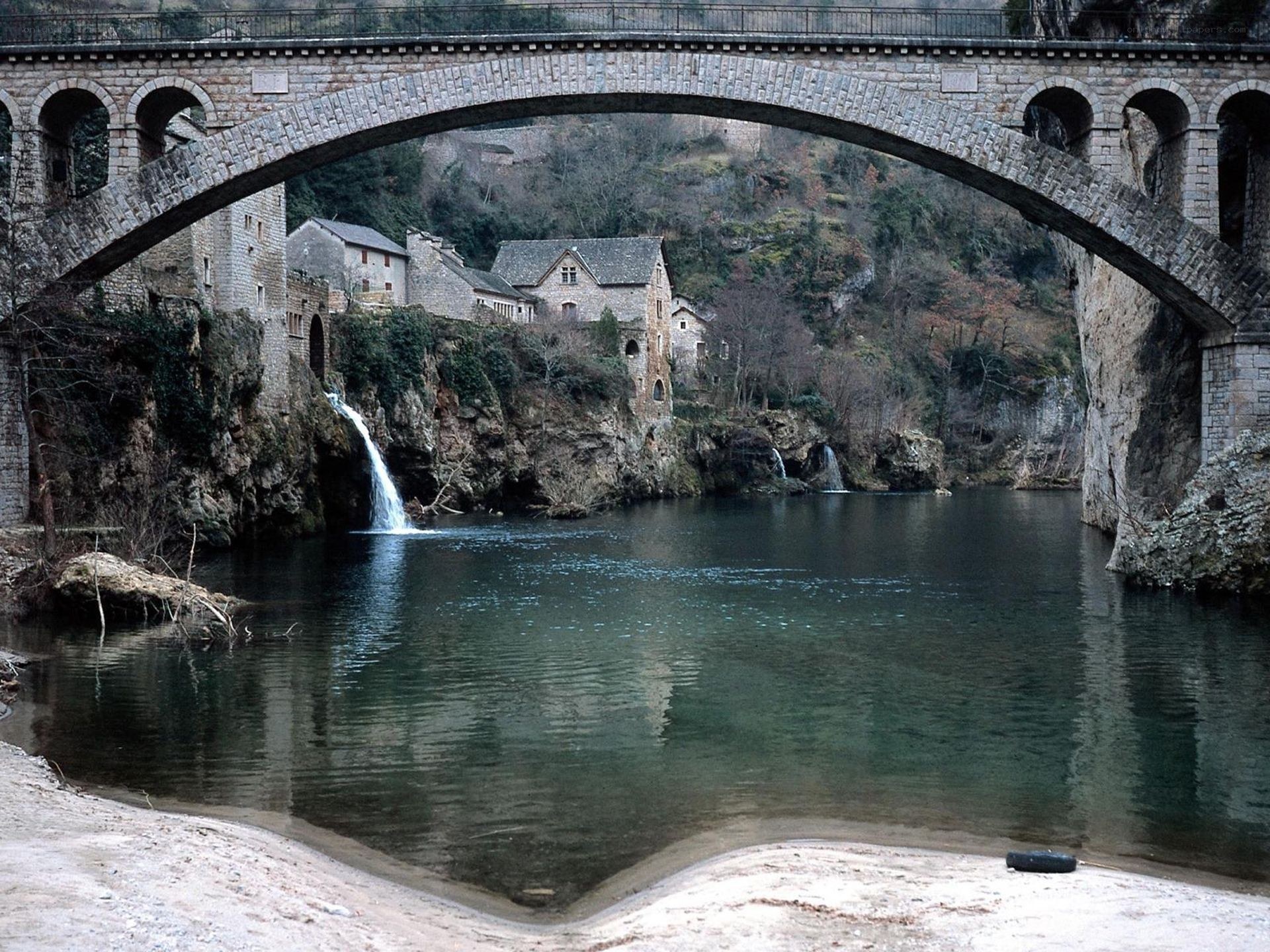 Stone bridge over river with waterfall