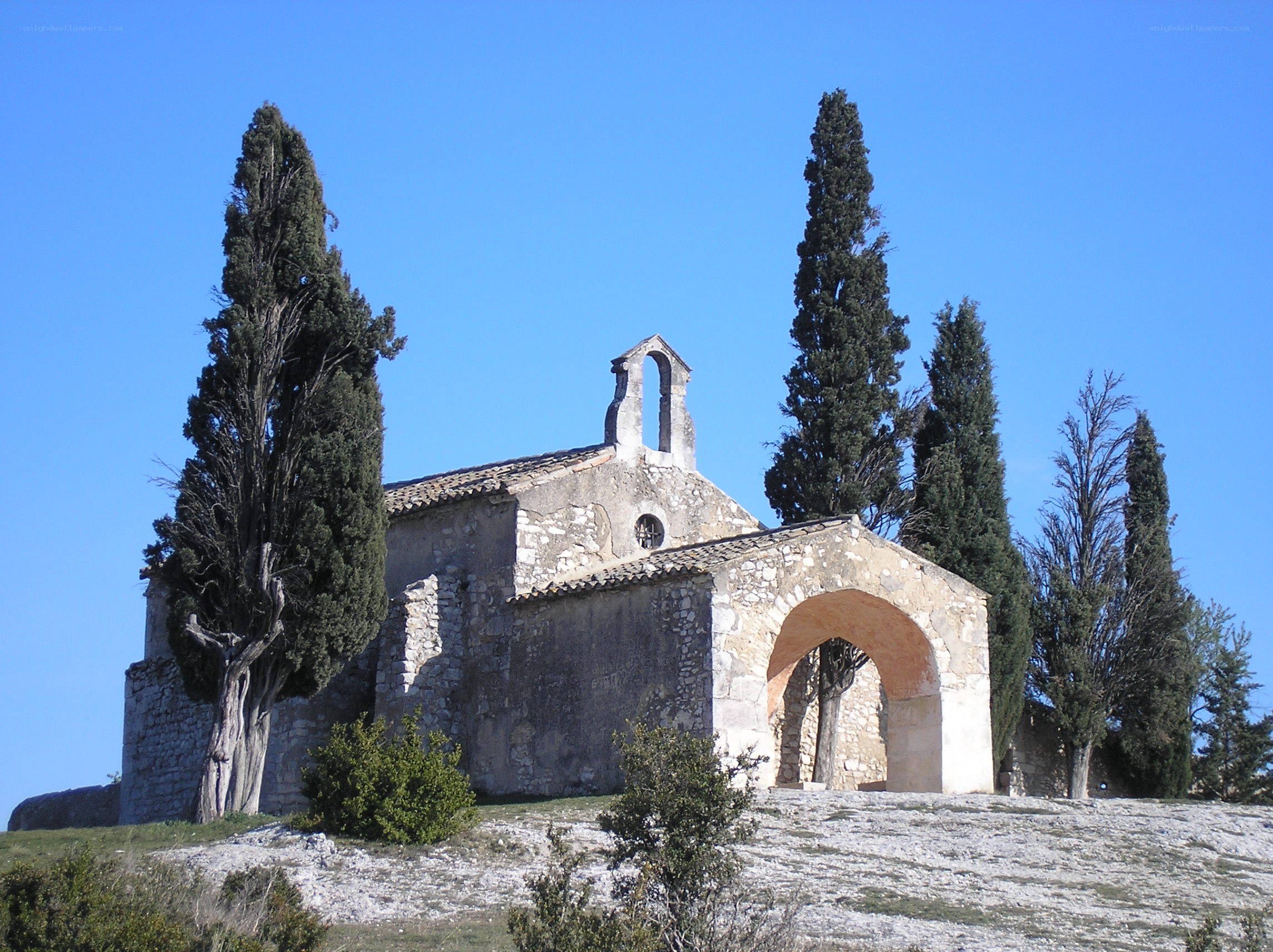 Stone chapel with cypress trees