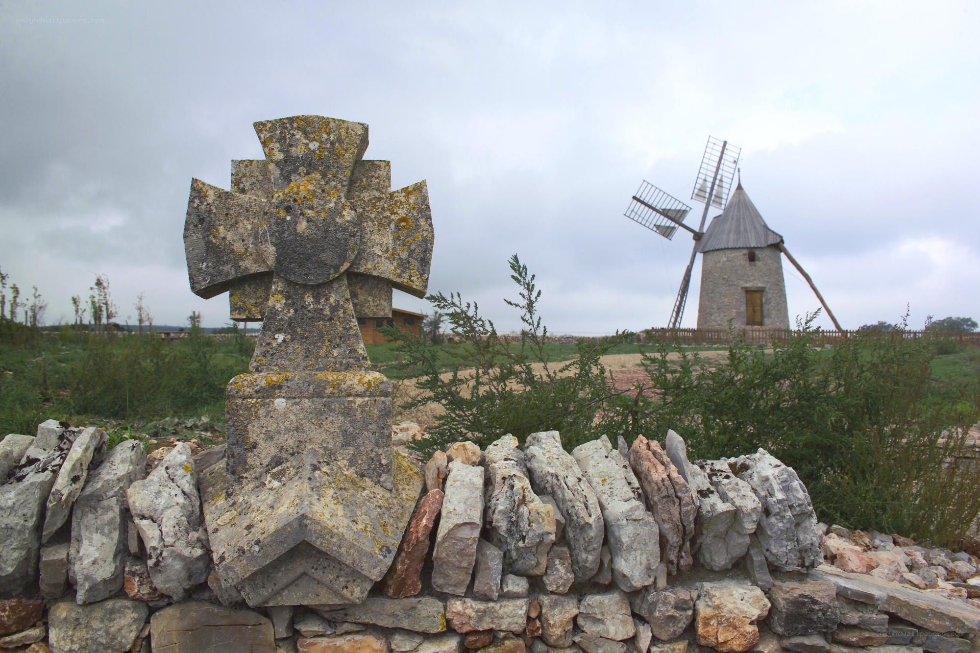 Stone cross and windmill landscape