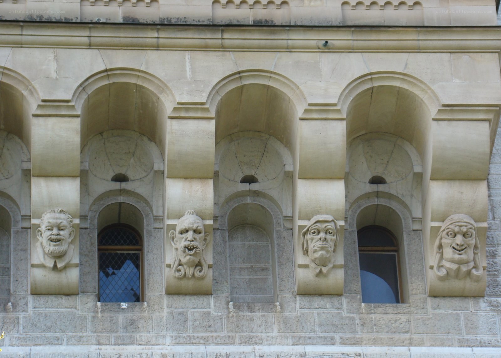 stone faces on building facade