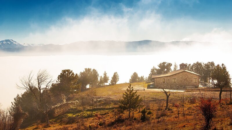 Stone house on a misty hill
