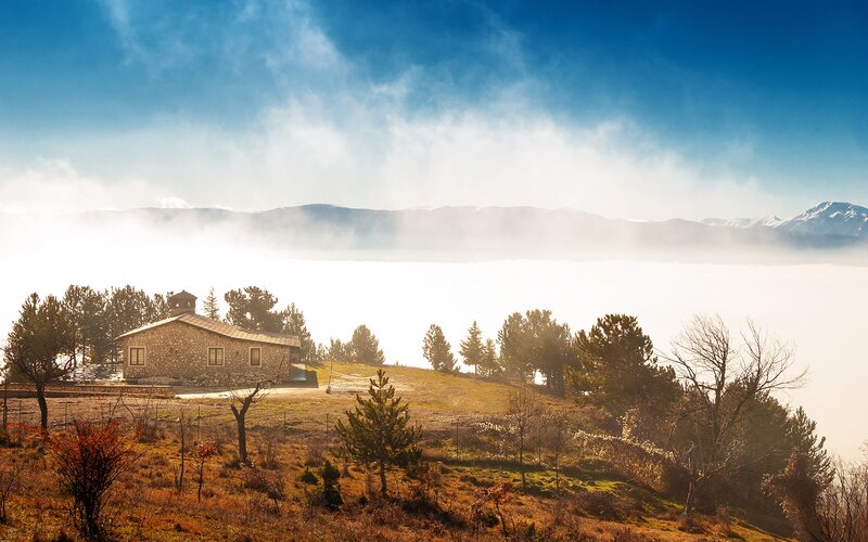 Stone house on a misty hill