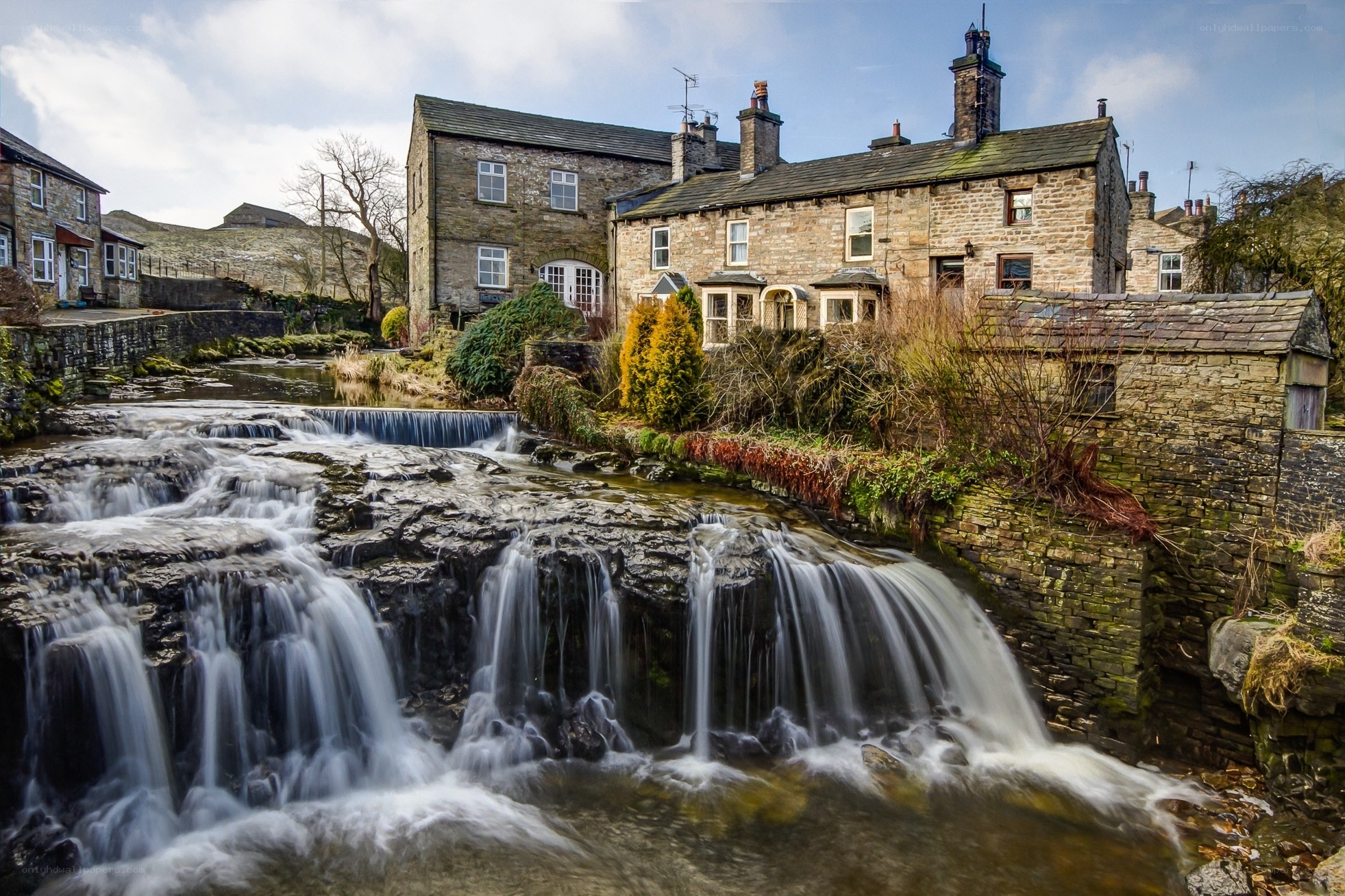 Stone houses by a cascading stream