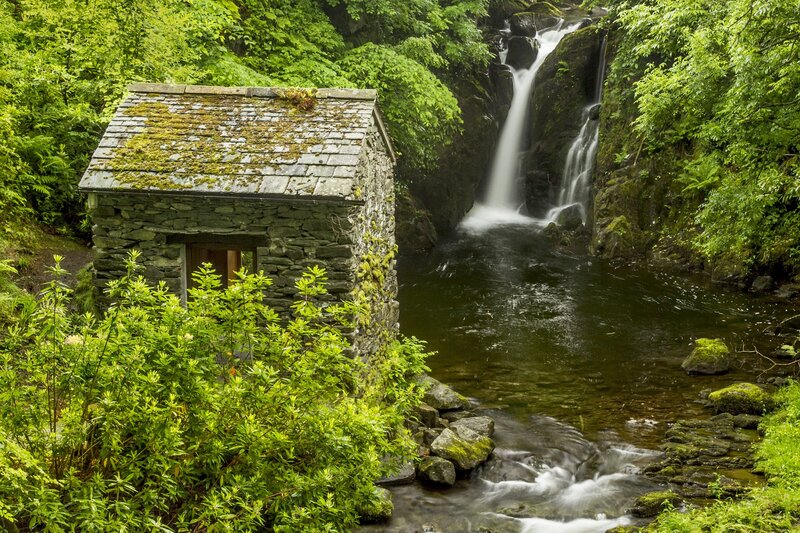 Stone hut by a waterfall