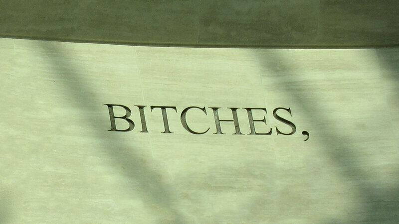 Stone inscription with word 'BITCHES,'