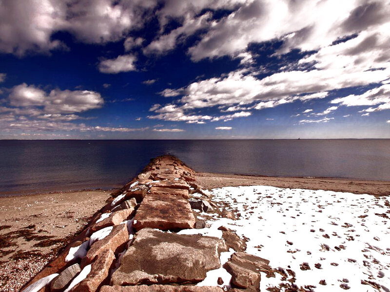 Stone jetty on a snowy beach