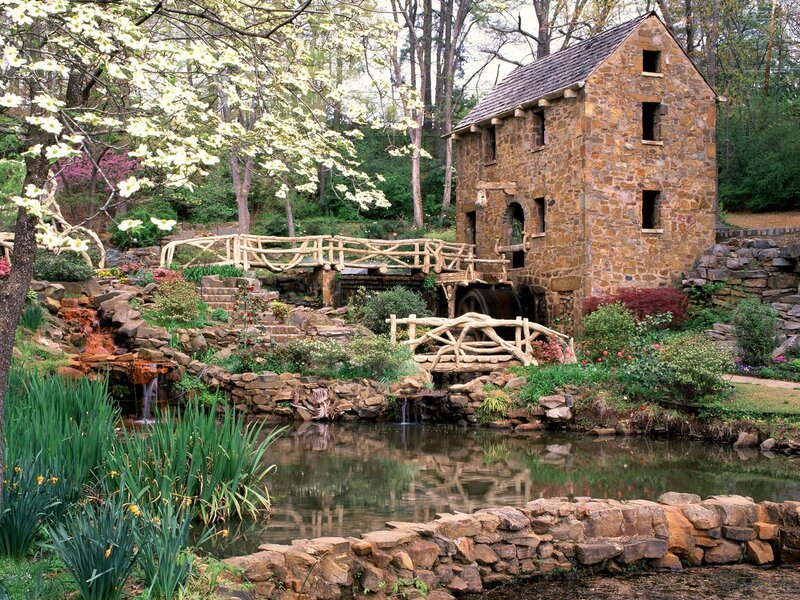 Stone mill by a garden pond