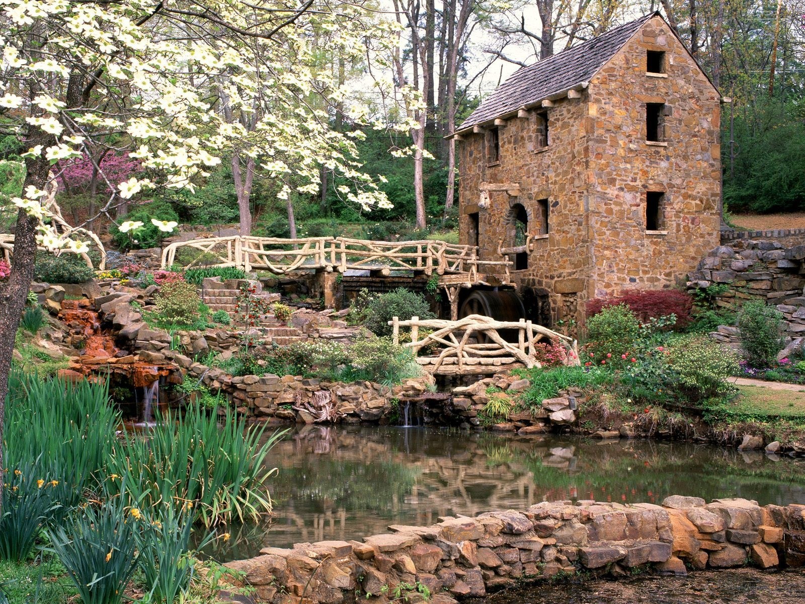 Stone mill by a garden pond