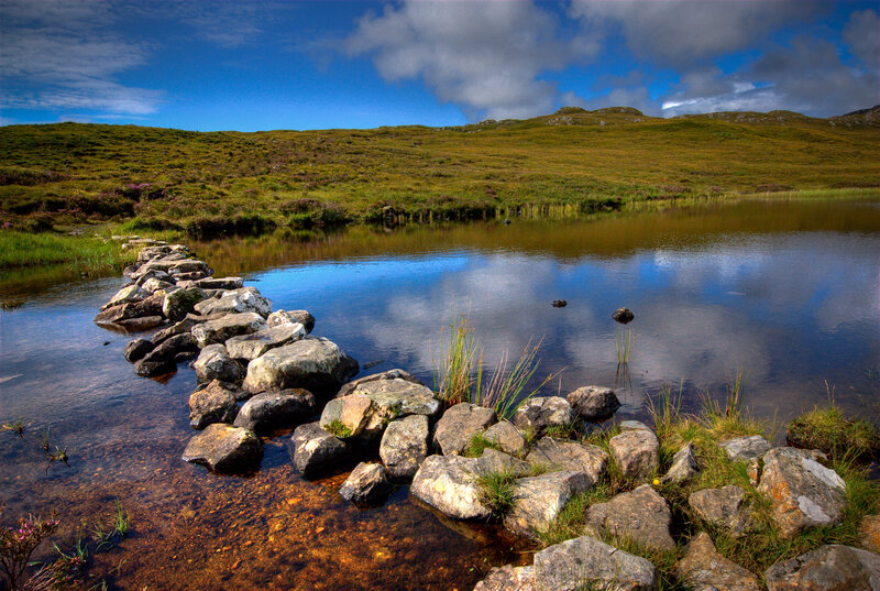 Stone path across a serene loch