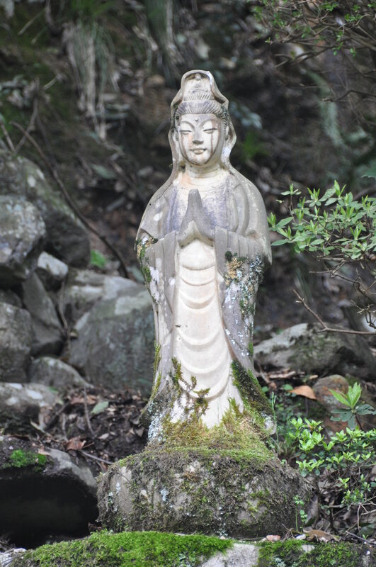 Stone statue of Guanyin in forest