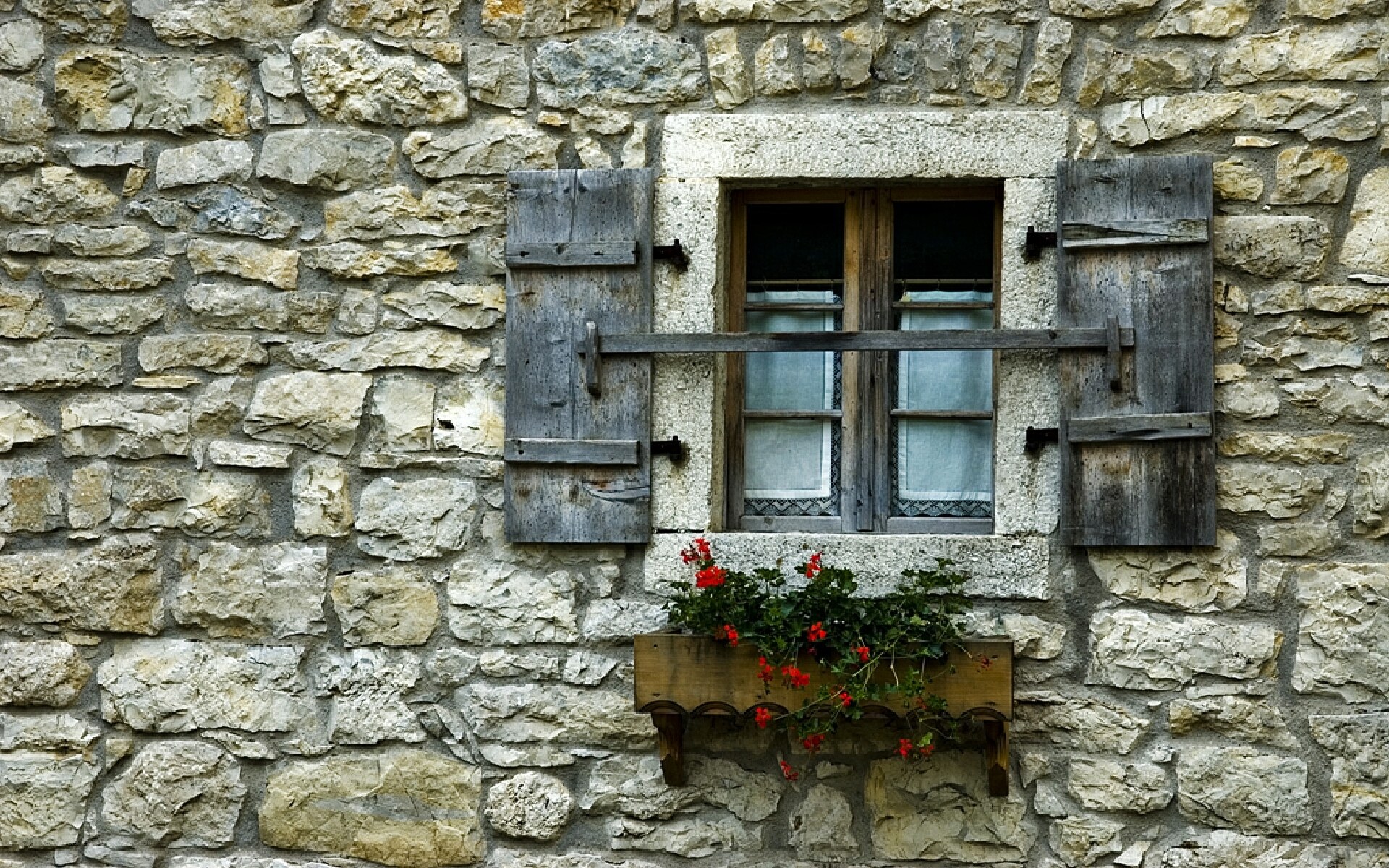 stone wall with window and flowers