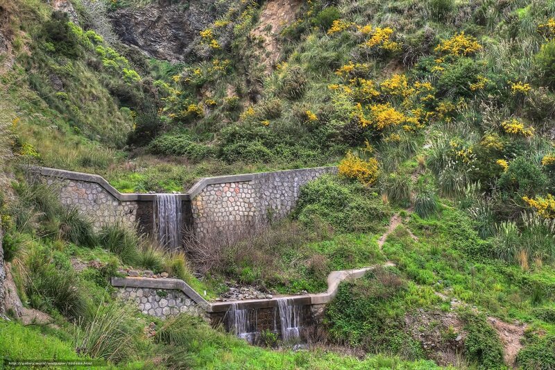 Stone waterfall in green valley