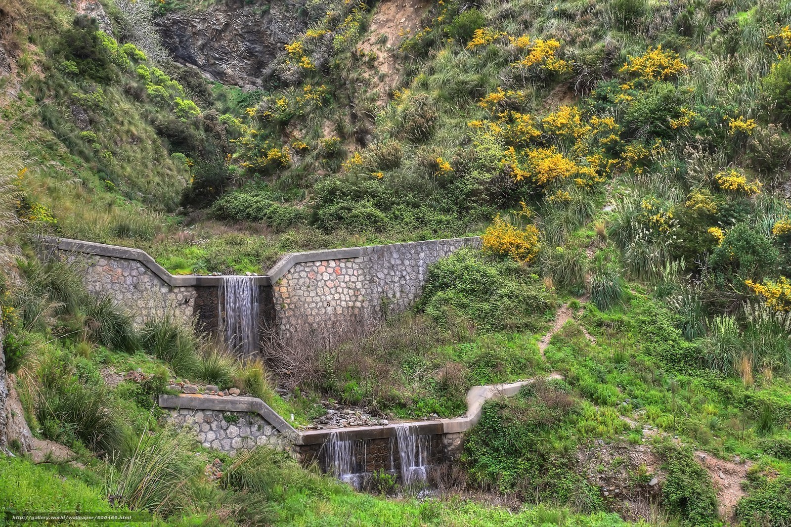Stone waterfall in green valley
