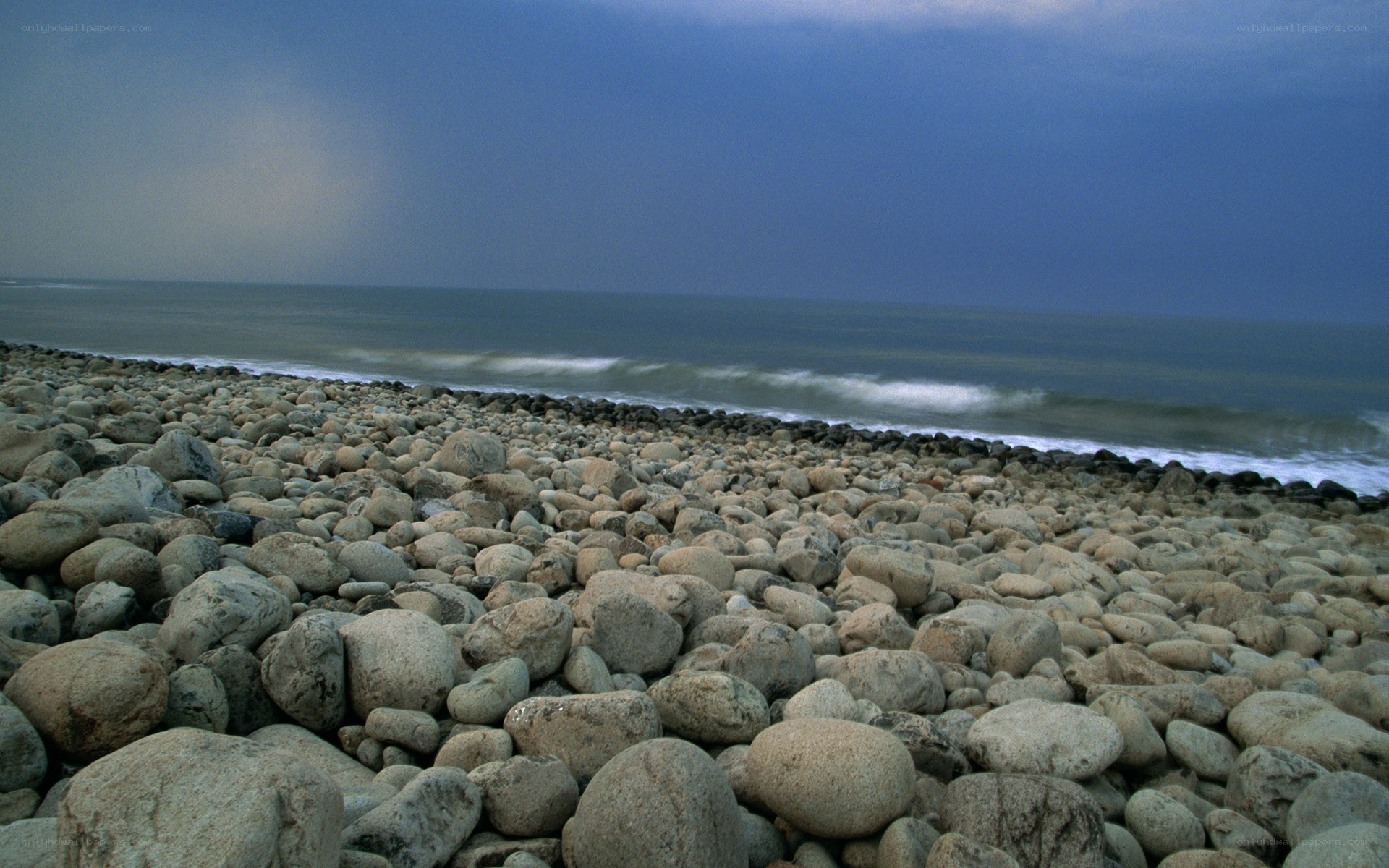 Stony beach under stormy sky