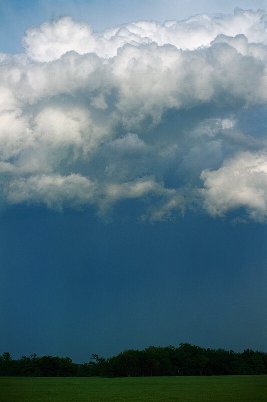 Storm clouds over a green field