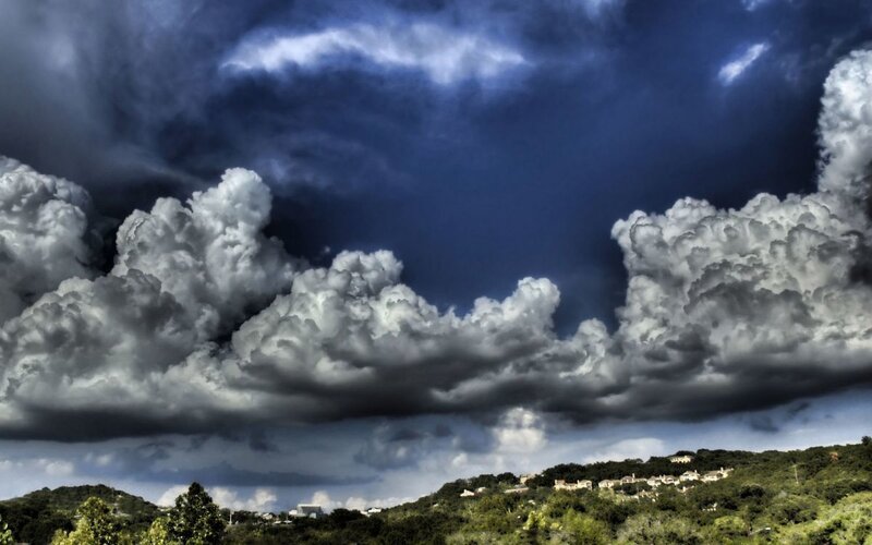 Storm clouds over a hillside town