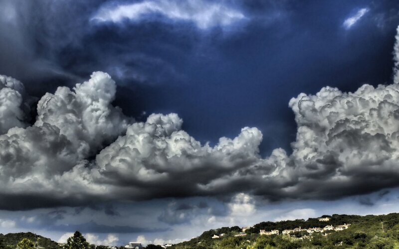 Storm clouds over a hillside town