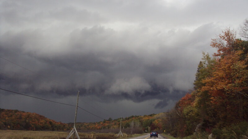 Storm clouds over autumn road
