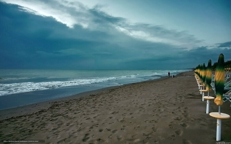 Stormy beach with closed umbrellas