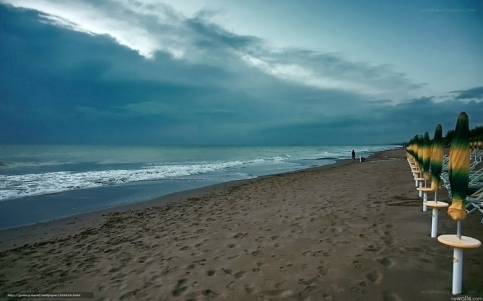 Stormy beach with closed umbrellas