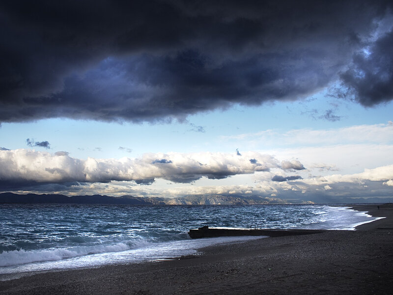 Stormy beach with distant mountains