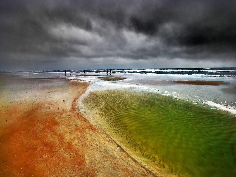 Stormy beach with green water