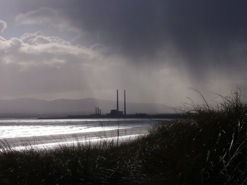 Stormy beach with industrial plant