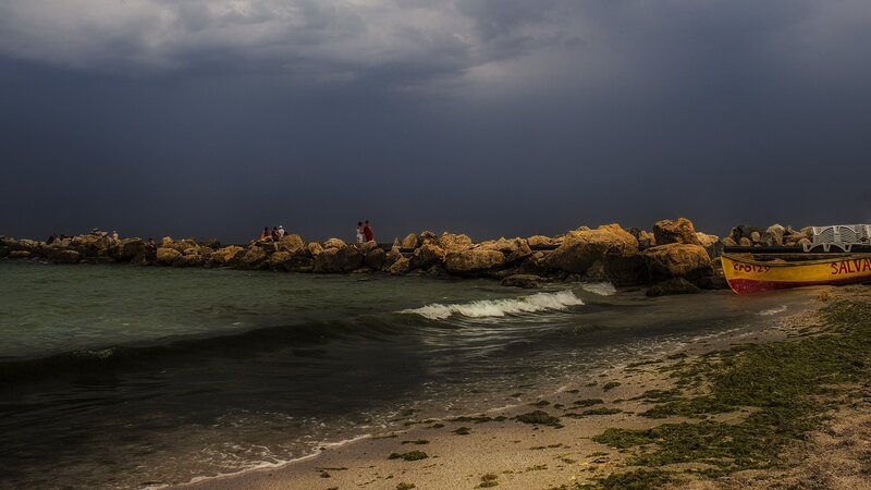 Stormy beach with rocky jetty