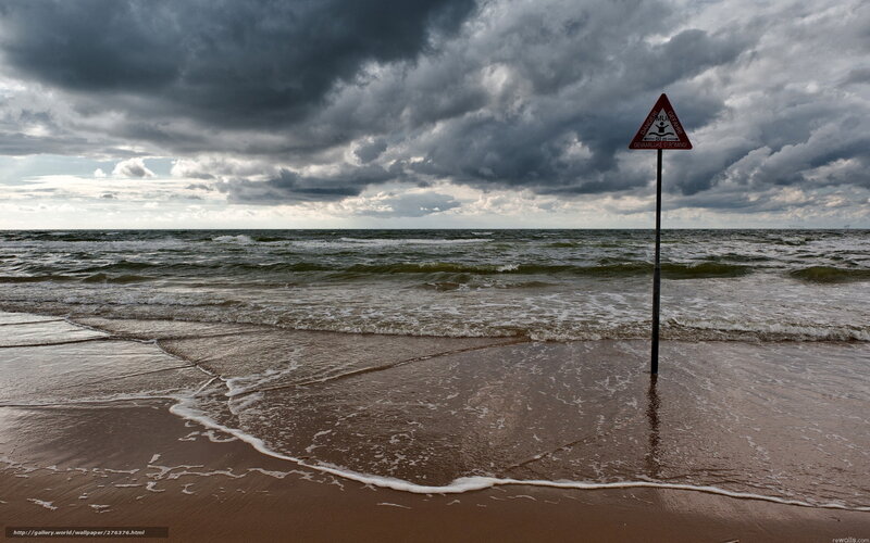Stormy beach with warning sign