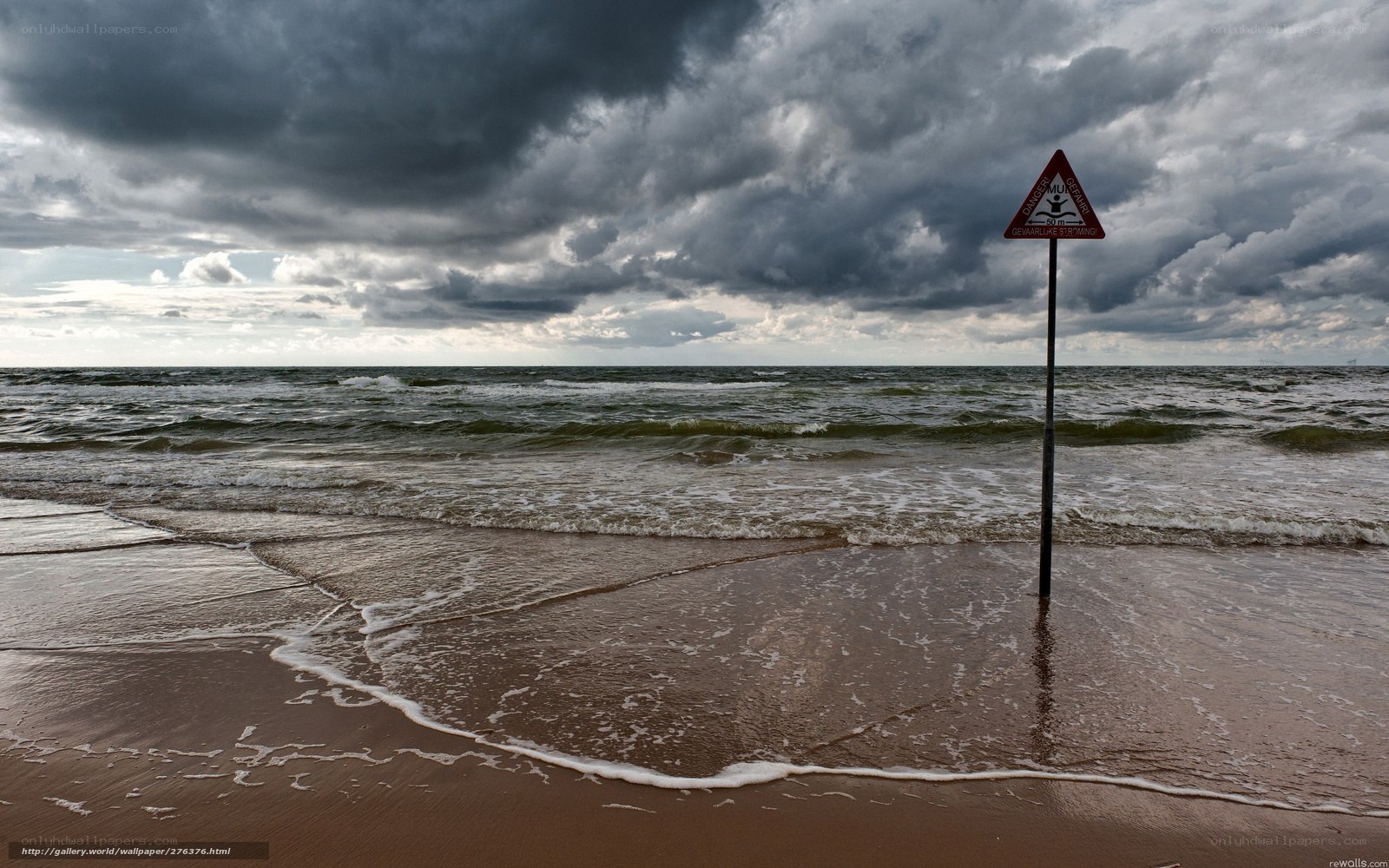 Stormy beach with warning sign