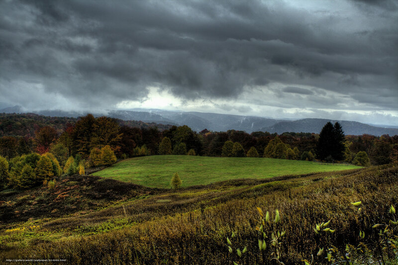 Stormy landscape with green field