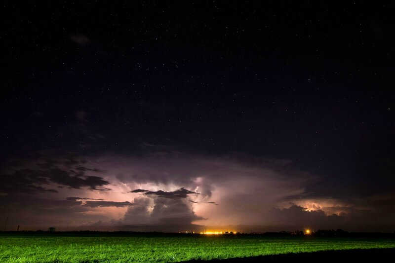 Stormy night over a green field