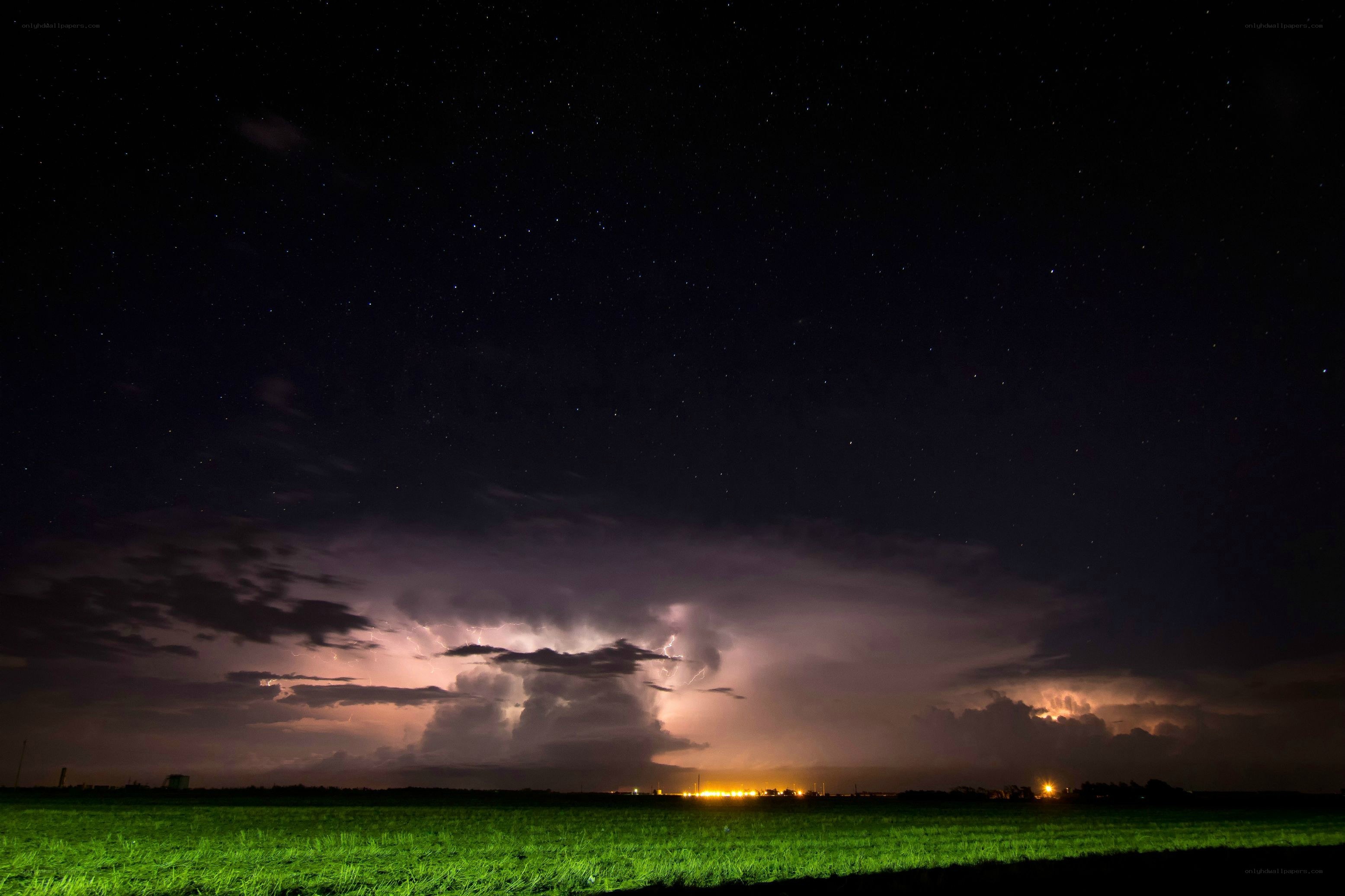 Stormy night over a green field