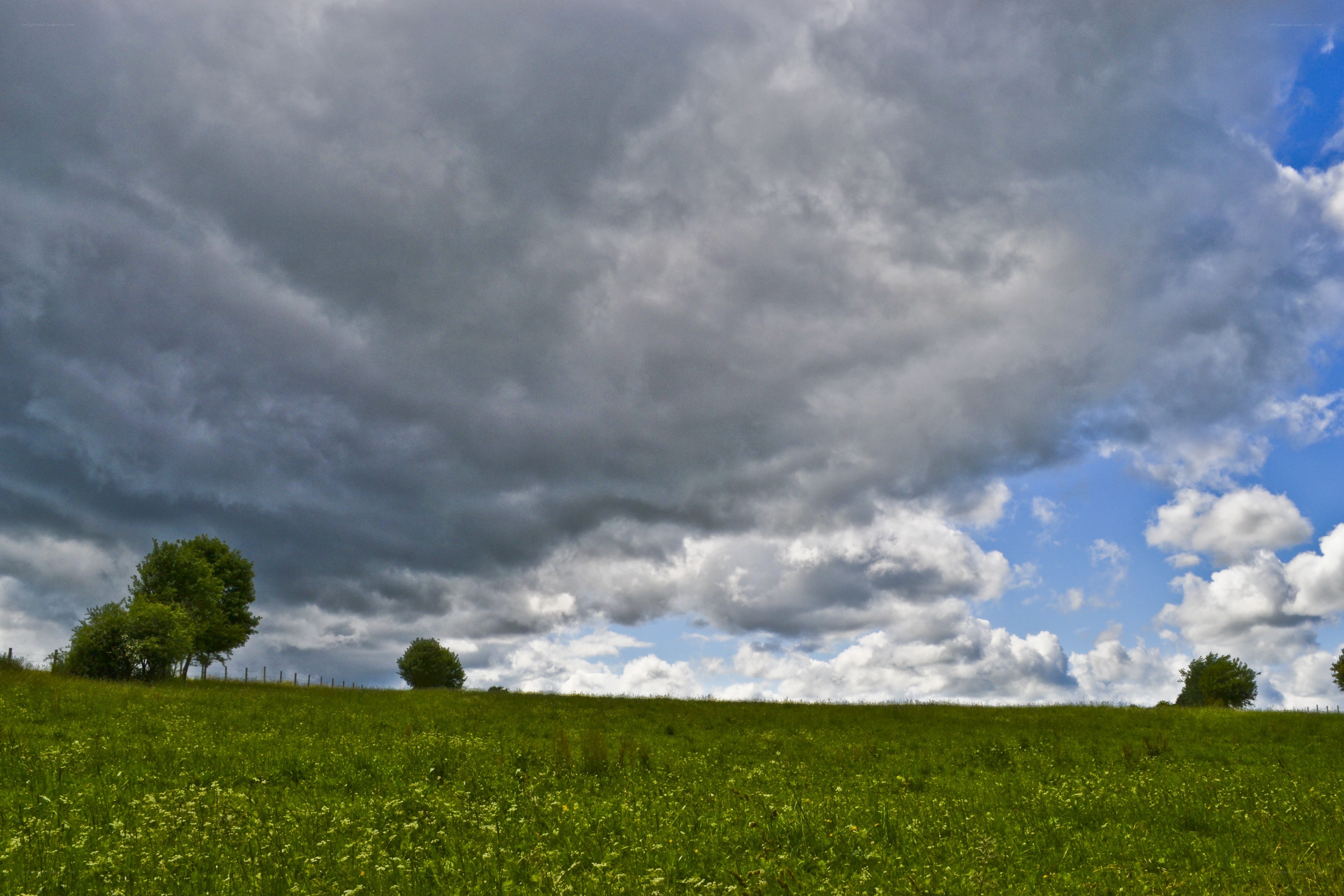 Stormy sky over green hill