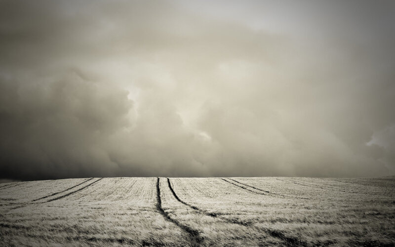 Stormy sky over plowed field