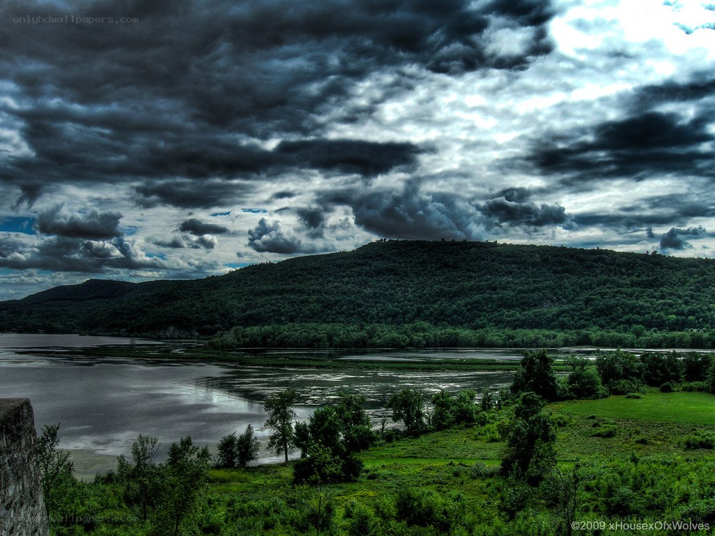 Stormy sky over river and hills